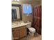 Functional bathroom features a single sink vanity, toilet, and a shower with a decorative curtain at 2411 W Lucia Dr, Phoenix, AZ 85085