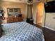 Bedroom with dark wood floors, large bed with patterned covers, view to a door to another room, and dresser at 2411 W Lucia Dr, Phoenix, AZ 85085