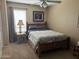 Cozy bedroom with neutral walls, a wooden bed frame, and a ceiling fan for added comfort at 2411 W Lucia Dr, Phoenix, AZ 85085