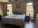 Spacious bedroom features wood floors, neutral walls, large bed, and two windows with blinds at 2411 W Lucia Dr, Phoenix, AZ 85085