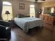 Bedroom with wood floors, large bed, dresser and mirror, and two windows with wooden blinds at 2411 W Lucia Dr, Phoenix, AZ 85085