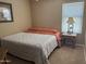 Bedroom features a large window, side table with lamp, and a comfortable bed with patterned linens at 2411 W Lucia Dr, Phoenix, AZ 85085