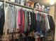 Organized closet featuring hanging clothes and neatly arranged bins on the upper shelf for optimal storage solutions at 2411 W Lucia Dr, Phoenix, AZ 85085