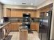 A kitchen featuring light wood cabinets, stainless steel appliances, and speckled granite countertops at 2411 W Lucia Dr, Phoenix, AZ 85085