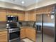 A kitchen featuring light wood cabinets, stainless steel appliances, and speckled granite countertops at 2411 W Lucia Dr, Phoenix, AZ 85085