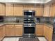 A kitchen featuring light wood cabinets, stainless steel appliances, and speckled granite countertops at 2411 W Lucia Dr, Phoenix, AZ 85085