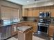 A kitchen featuring light wood cabinets, stainless steel appliances, and speckled granite countertops at 2411 W Lucia Dr, Phoenix, AZ 85085