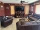 Spacious living room with leather couches, a TV, and a ceiling fan at 2411 W Lucia Dr, Phoenix, AZ 85085