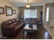 Living room with wood floors, two brown leather couches, and decor at 2411 W Lucia Dr, Phoenix, AZ 85085