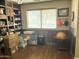 Home office with hardwood floors, custom shelving, and plenty of room for both work and storage at 2411 W Lucia Dr, Phoenix, AZ 85085