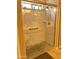 Shower with glass doors and clear glass walls, plus a shower seat and safety bar at 2411 W Lucia Dr, Phoenix, AZ 85085