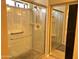 Shower with glass doors and clear glass walls, plus a shower seat and safety bar at 2411 W Lucia Dr, Phoenix, AZ 85085