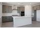 Bright kitchen features quartz counters, stainless steel appliances, and modern gray cabinets at 24232 W Agora Ln, Buckeye, AZ 85326