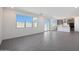Open floor plan shows modern tile flooring, neutral walls, a sliding glass door, and adjacent kitchen at 24232 W Agora Ln, Buckeye, AZ 85326