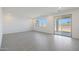 Bright living room features modern tile flooring, neutral walls, and a sliding glass door at 24232 W Agora Ln, Buckeye, AZ 85326