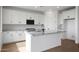 Modern kitchen with white cabinetry, granite countertops, stainless steel appliances, and wood flooring at 24249 W Agora Ln, Buckeye, AZ 85326