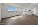 Spacious living room featuring tile floors, large windows, and an open floor plan to the kitchen at 24249 W Agora Ln, Buckeye, AZ 85326