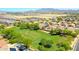 Aerial shot showcases the neighborhood with a large open green space, homes with solar panels and mountain views at 2726 S 160Th Ave, Goodyear, AZ 85338