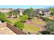 A spacious backyard is complimented by desert landscaping, mature trees, and green grass at 2726 S 160Th Ave, Goodyear, AZ 85338