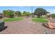 Spacious backyard featuring decorative rock ground cover, green grass, and mature trees at 2726 S 160Th Ave, Goodyear, AZ 85338