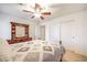 Comfortable bedroom with carpet floors, a ceiling fan, closet and a beautiful display cabinet at 2726 S 160Th Ave, Goodyear, AZ 85338