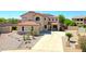 Beautiful two-story home with a tile roof, arched windows, desert landscaping, and a spacious driveway at 2726 S 160Th Ave, Goodyear, AZ 85338