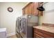 Well-equipped laundry room with modern washer and dryer, granite countertop, and overhead cabinets at 2726 S 160Th Ave, Goodyear, AZ 85338