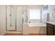 Main bathroom featuring a separate glass shower, soaking tub with white trim, and a window at 2726 S 160Th Ave, Goodyear, AZ 85338