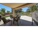 Outdoor patio area with seating and views of the meticulously landscaped backyard and mature trees at 2726 S 160Th Ave, Goodyear, AZ 85338