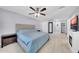 Bright bedroom features light wood floors, light blue bedding, ceiling fan, and fireplace at 2820 E Surrey Ave, Phoenix, AZ 85032