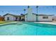 Inviting pool area with a turquoise pool, palm trees, string lights, and white brick exterior at 2820 E Surrey Ave, Phoenix, AZ 85032