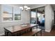 Cozy dining area with a wooden table, bench seating, plantation shutters, and a view of the outdoor patio at 2915 W Night Owl Ln, Phoenix, AZ 85085