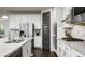 Modern kitchen featuring stainless steel appliances, white cabinets, granite countertops, and a view of the sleek cooktop at 2915 W Night Owl Ln, Phoenix, AZ 85085