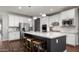 Bright kitchen boasts white cabinetry, stainless steel appliances, granite countertops, and a spacious center island with seating at 2915 W Night Owl Ln, Phoenix, AZ 85085