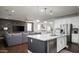 Open-concept kitchen and living room featuring a large island, stainless appliances, and a comfortable gray sectional sofa at 2915 W Night Owl Ln, Phoenix, AZ 85085