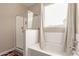 Bathroom boasts a glass door shower and soaking tub under a bright window at 30089 W Rockmount Ave, Buckeye, AZ 85396