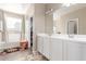 Bathroom features dual sinks and cabinets, a large mirror, and a tub at 30089 W Rockmount Ave, Buckeye, AZ 85396
