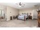 Spacious bedroom features a ceiling fan, neutral walls and carpet, and wood furniture at 30089 W Rockmount Ave, Buckeye, AZ 85396