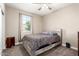 Cozy bedroom features neutral walls, carpet flooring, ceiling fan, and natural light from the window at 30089 W Rockmount Ave, Buckeye, AZ 85396