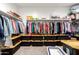 Walk in closet with rows of clothes and plastic storage bins at 30089 W Rockmount Ave, Buckeye, AZ 85396
