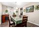 Inviting dining room with elegant chandelier, decorative fireplace, and hardwood floors at 30089 W Rockmount Ave, Buckeye, AZ 85396