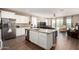 Stylish kitchen island with granite countertops, stainless steel appliances, and a view to the living room at 30089 W Rockmount Ave, Buckeye, AZ 85396