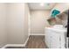 Laundry room features wood-look flooring, washer and dryer, shelving, and neutral walls at 30089 W Rockmount Ave, Buckeye, AZ 85396