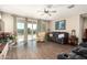 Cozy living room with tile floors, a ceiling fan, and sliding glass doors to the patio at 30089 W Rockmount Ave, Buckeye, AZ 85396