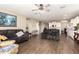Spacious living room featuring a ceiling fan, wood floors, and an open layout to the kitchen at 30089 W Rockmount Ave, Buckeye, AZ 85396