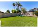 Artificial lawn with blue Adirondack chairs provides a relaxing backyard seating area at 4316 E Janice Way, Phoenix, AZ 85032