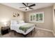 Neutral bedroom featuring a window with shutters, ceiling fan, and side table with lamp at 4316 E Janice Way, Phoenix, AZ 85032