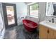 Modern bathroom with red tub, marble accents, and a sleek door leading to an outdoor patio at 4609 E Adobe Dr, Phoenix, AZ 85050