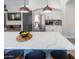 Kitchen island with seating overlooks stainless steel refrigerator and modern white cabinetry at 4609 E Adobe Dr, Phoenix, AZ 85050