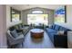 Cozy living room featuring comfortable sofas, a round coffee table, and large windows at 4609 E Adobe Dr, Phoenix, AZ 85050